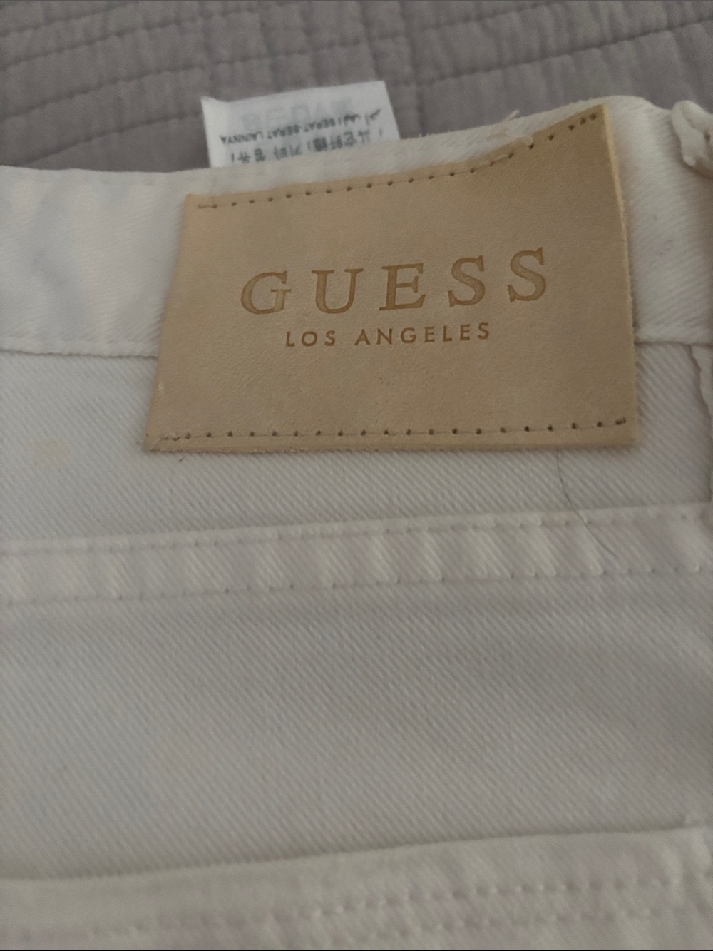 Guess Men’s Jeans White with intentional, distressing, and paint splatter